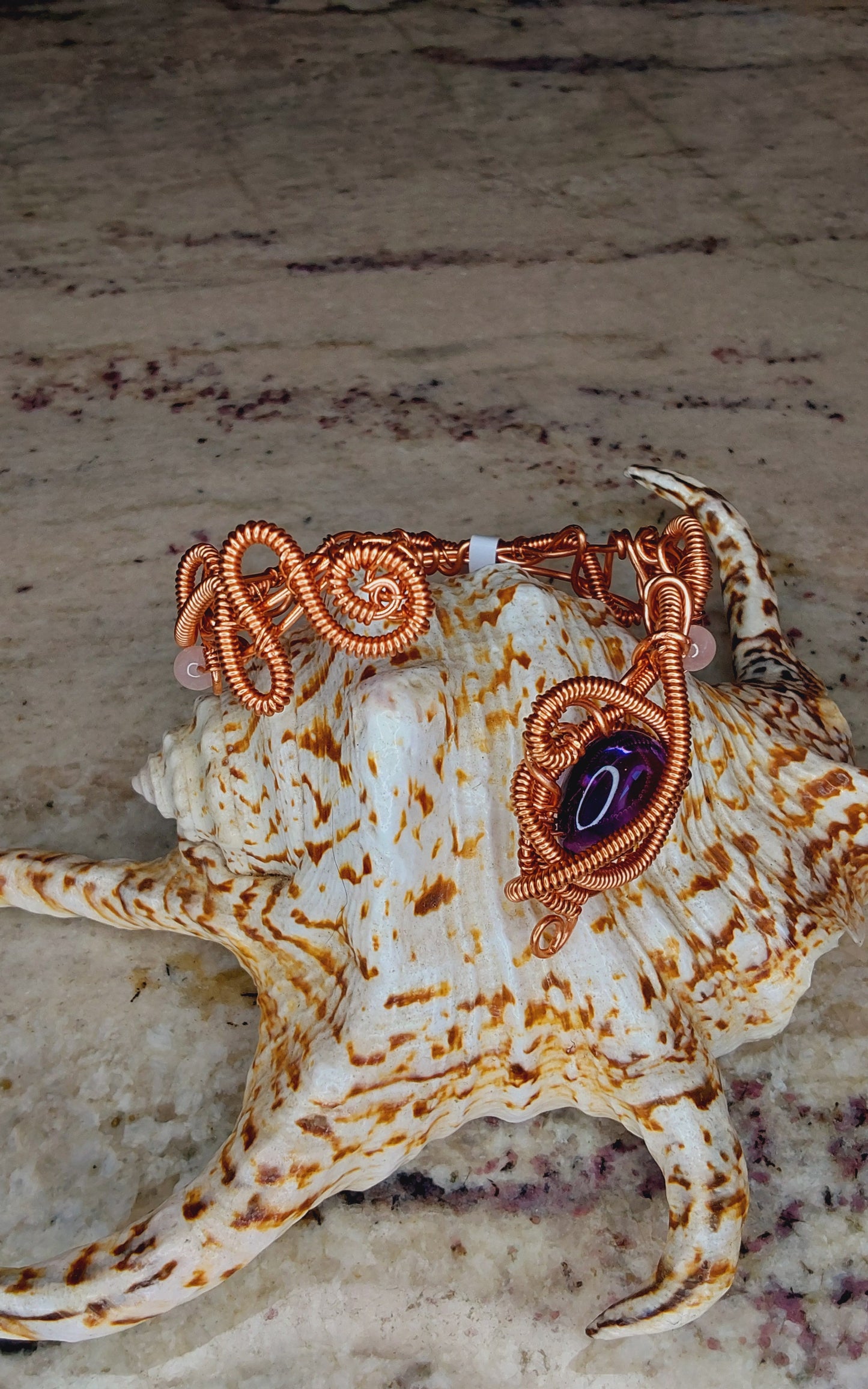 Copper wire-wrapped bracelet with an amethyst crystal
