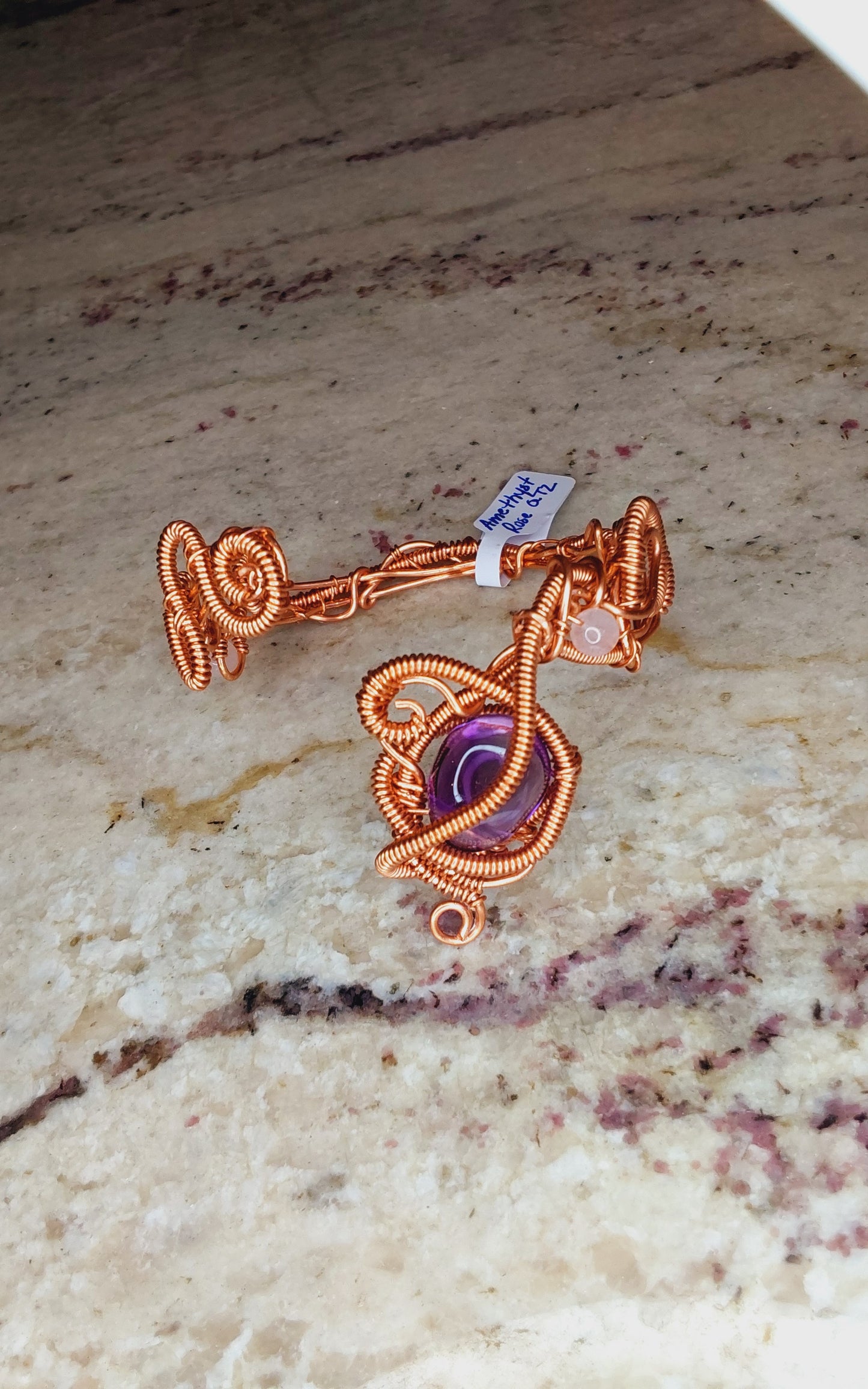 Copper wire-wrapped bracelet with an amethyst crystal