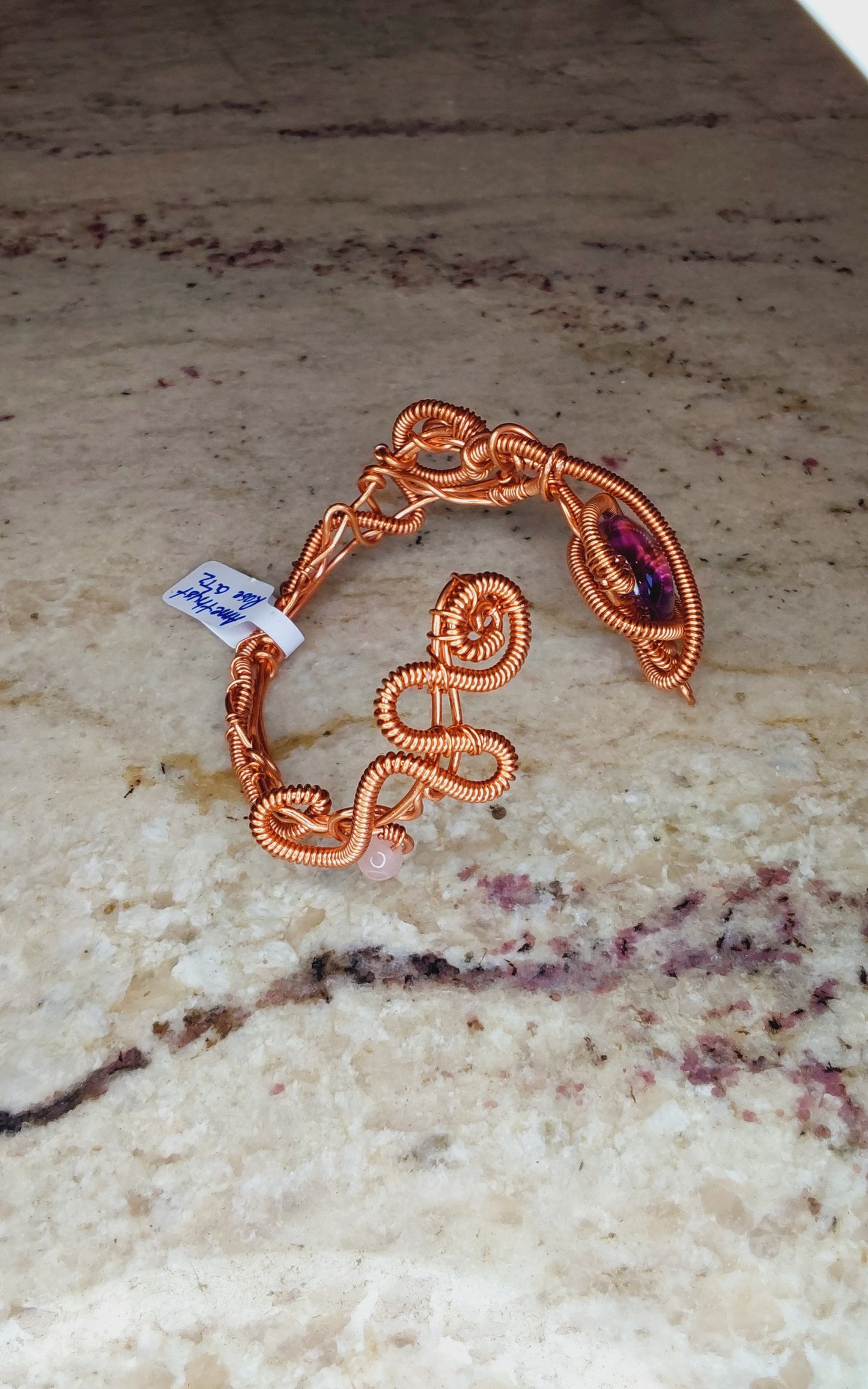 Copper wire-wrapped bracelet with an amethyst crystal