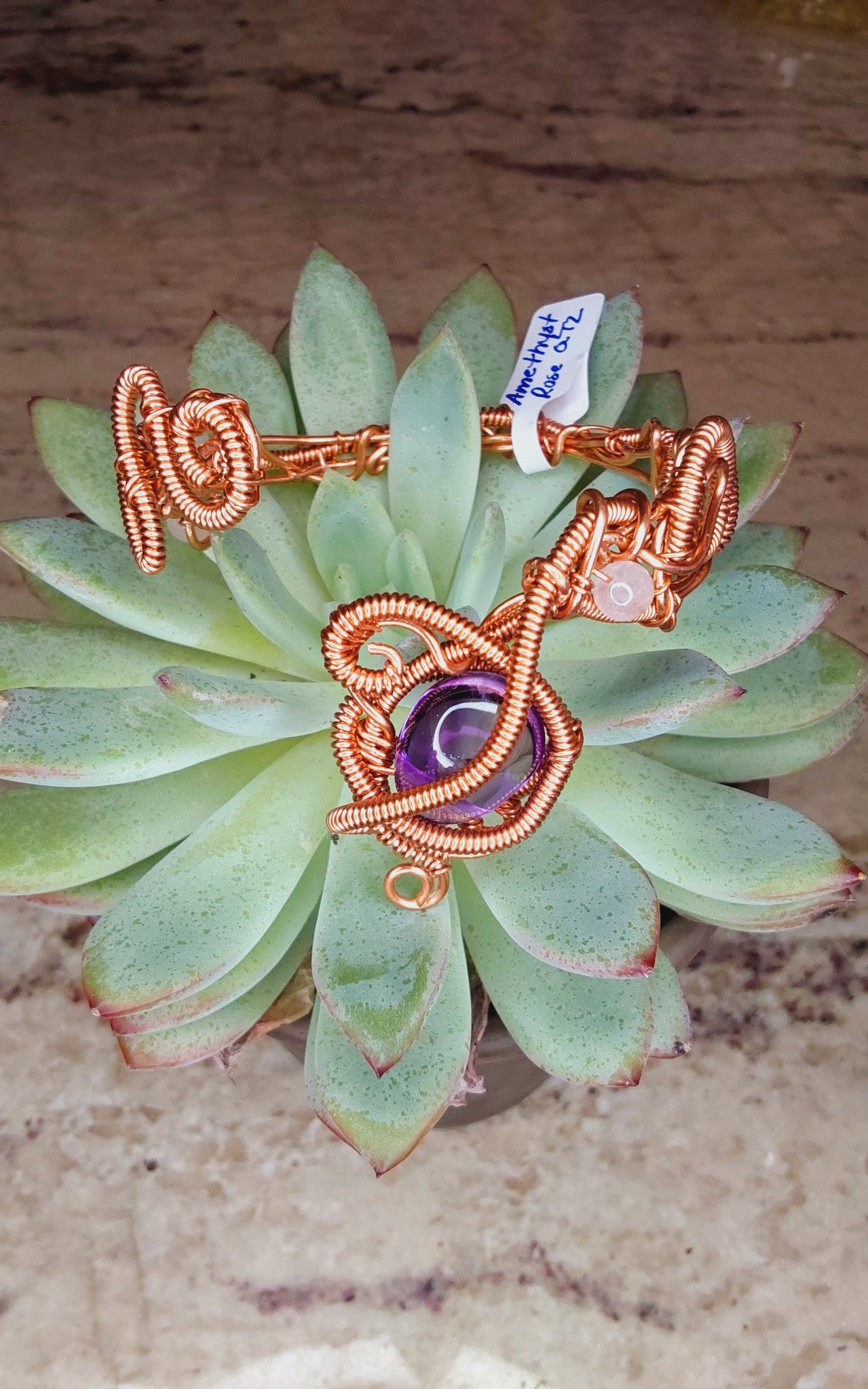Copper wire-wrapped bracelet with an amethyst crystal