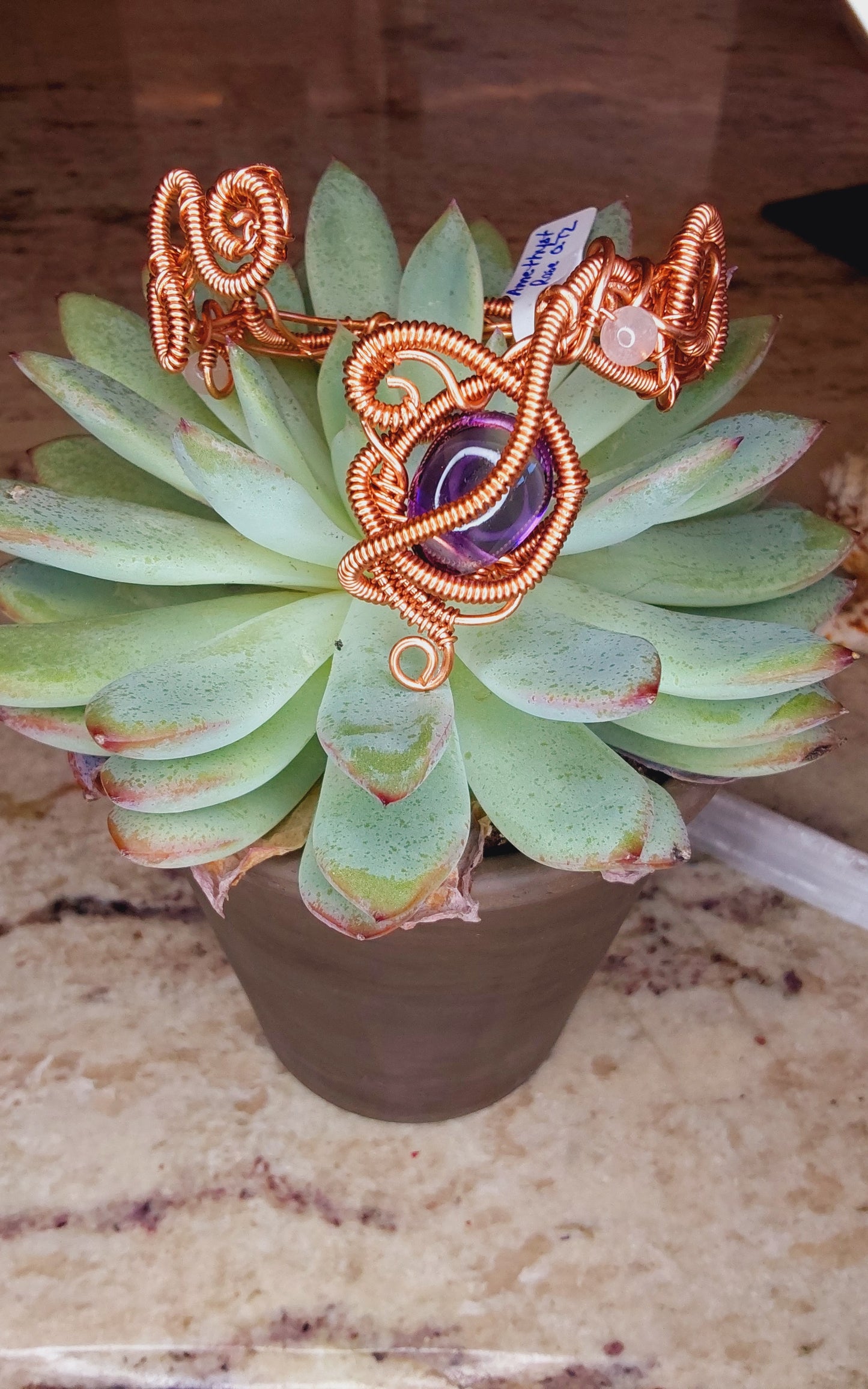 Copper wire-wrapped bracelet with an amethyst crystal