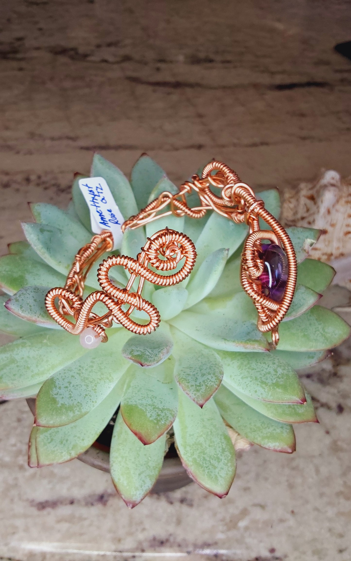 Copper wire-wrapped bracelet with an amethyst crystal